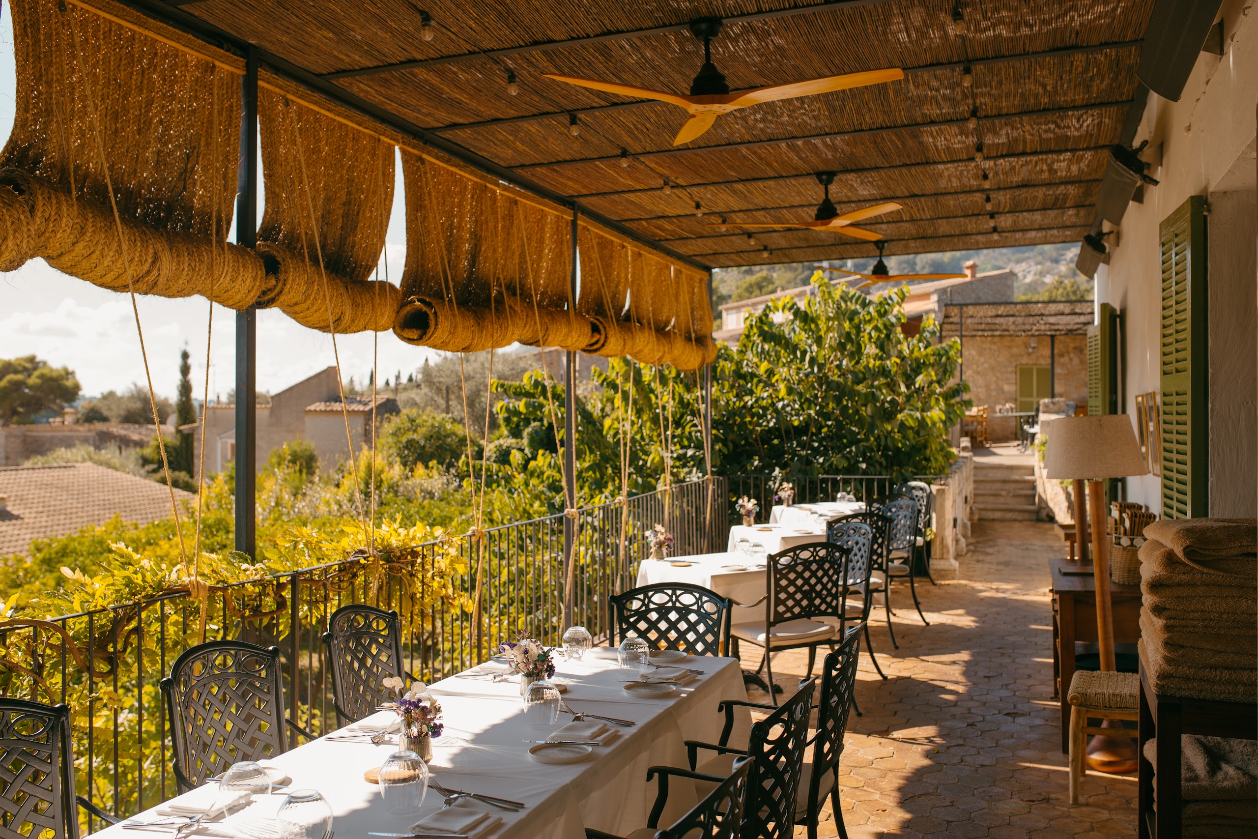 Terraza del restaurante Mirabona con mesas vestidas y vistas a la Serra de Tramuntana